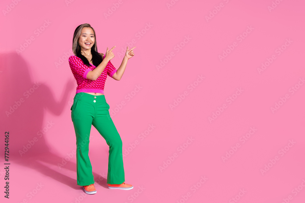 Full length photo of impressed funky lady dressed knitted shirt showing two fingers emtpy space isolated pink color background - obrazy, fototapety, plakaty 