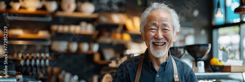 An elderly man stands in a café, smiling with joy, welcoming visitors with warmth and confidence.