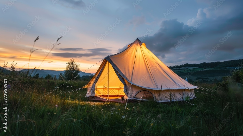 Illuminated tent at twilight in the mountains