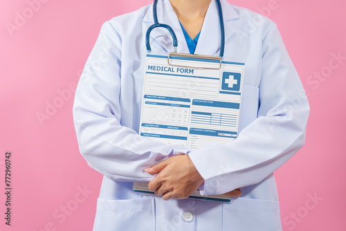 Holding clipboard medical form, Close up female medical doctor isolated on pink background.