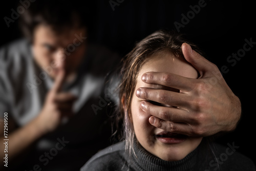 Child, domestic violence and depression with hand on mouth for silence, abuse and sad in relationship. photo