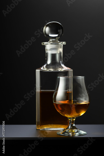 Old decanter and glass with whiskey, cognac or brandy.
