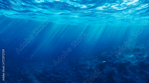 Sunlight shining through the water's surface in a deep blue ocean