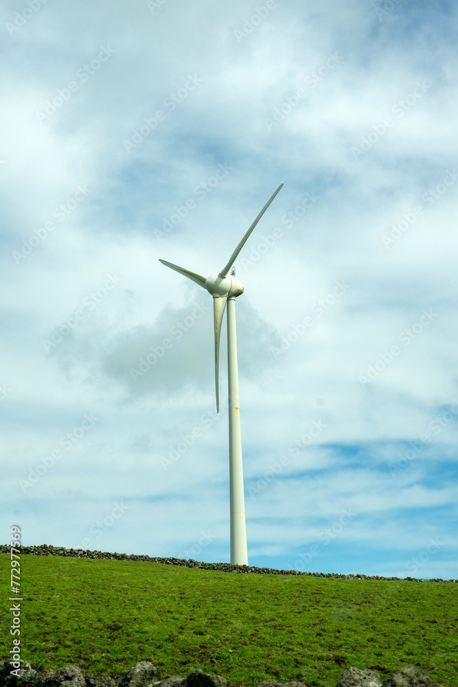 Wind turbines stand tall against a cloudy sky on Terceira Island, Azores. Capturing renewable energy in picturesque surroundings. Wind turbines stand tall against a cloudy sky on Terceira Island, Azores. Capturing renewable energy in picturesque surroundings.