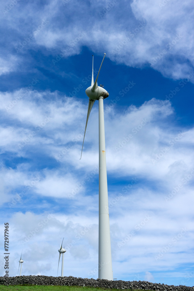 Wind turbines stand tall against a cloudy sky on Terceira Island, Azores. Capturing renewable energy in picturesque surroundings. Wind turbines stand tall against a cloudy sky on Terceira Island, Azores. Capturing renewable energy in picturesque surroundings.