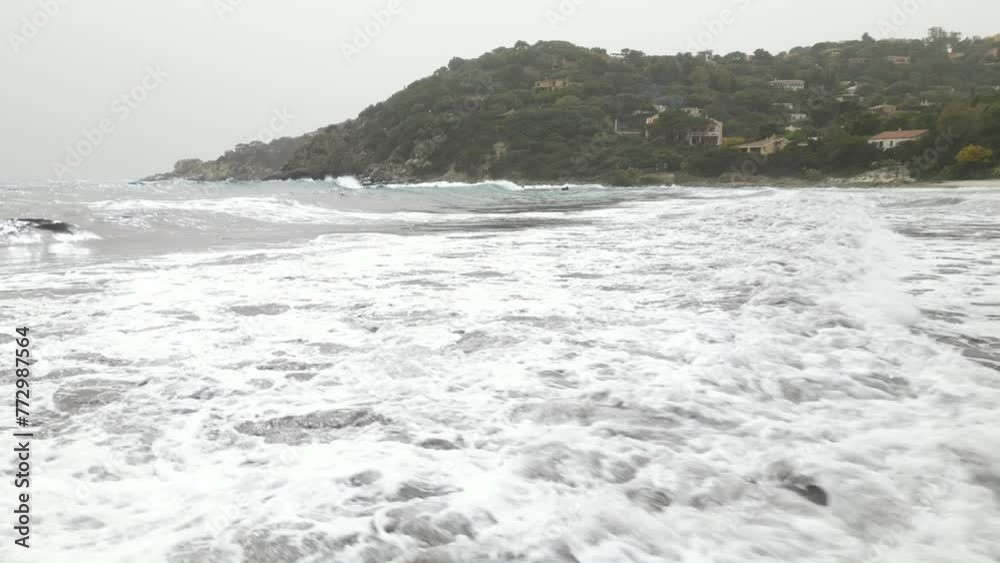 Windy day on a beach in Sardinia. High sea waves full of water. Cloudy Windy day on a beach in Sardinia. High sea waves full of water. Cloudy