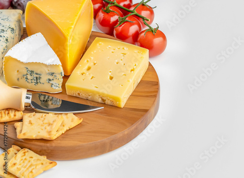 cheeses on a wooden board with a cheese knife