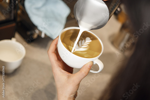 Barista Crafting Latte Art During Busy Morning Hours at Local Coffee Shop photo