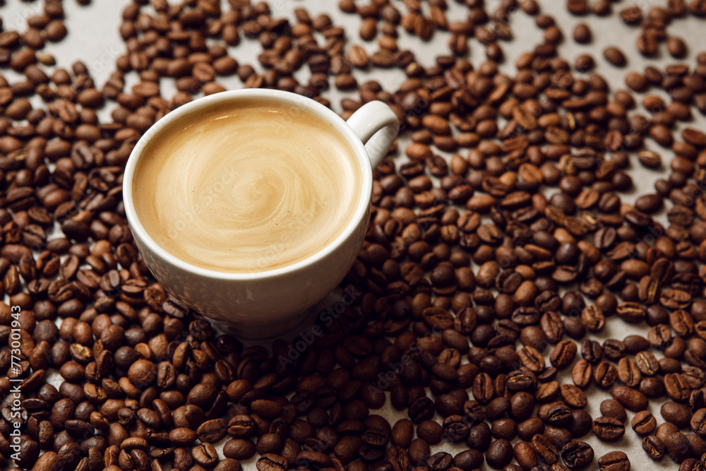 Cup of Creamy Cappuccino Surrounded by Roasted Coffee Beans on Table Cup of Creamy Cappuccino Surrounded by Roasted Coffee Beans on Table