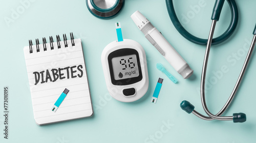 Diabetes concept with blood glucose sugar meter and stethoscope on green background
