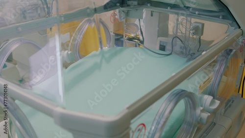 Within neonatal intensive care unit series of advanced incubators cater to needs of preterm infants. Gentle glow emanating from equipment illuminates room symbolizing hope and resilience. photo