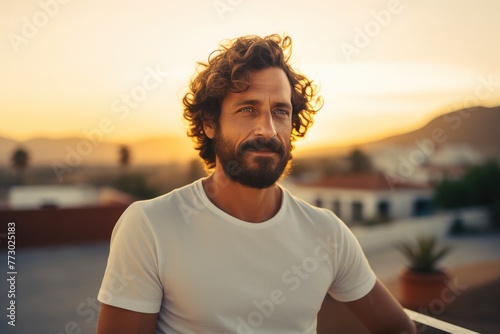 Casually Dressed Man with Beard and Curly Hair Sitting Comfortably