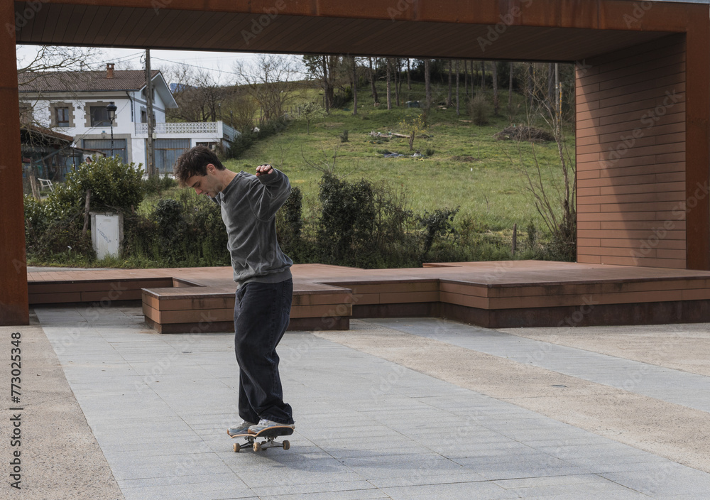 Skater practicing tricks at a public skate area, copy space. Skater practicing tricks at a public skate area, copy space.