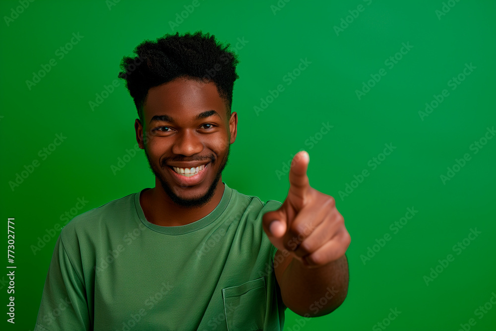 Choose this. African american male person with toothy smile on face pointing with index finger on empty space over green background. Handsome young guy indicating place for advertising text in studio Choose this. African american male person with toothy smile on face pointing with index finger on empty space over green background. Handsome young guy indicating place for advertising text in studio