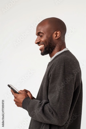 View from the side of a man, with serene smile, holding a smartphone, 