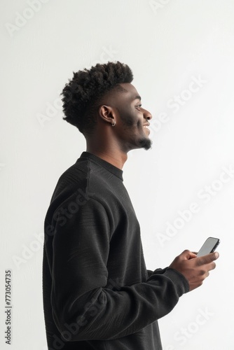 View from the side of a man, with serene smile, holding a smartphone, 