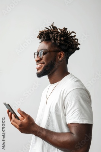 View from the side of a man, with serene smile, holding a smartphone, against white background, 