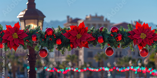 A red and green Christmas wreath with red poinsettias and red and green balls. The wreath is hanging from a lamp post