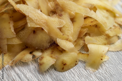 Pile of potato peels on a wooden cutting board