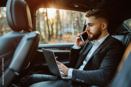 Businessman Multitasking with Laptop and Phone in Car Backseat © KirKam