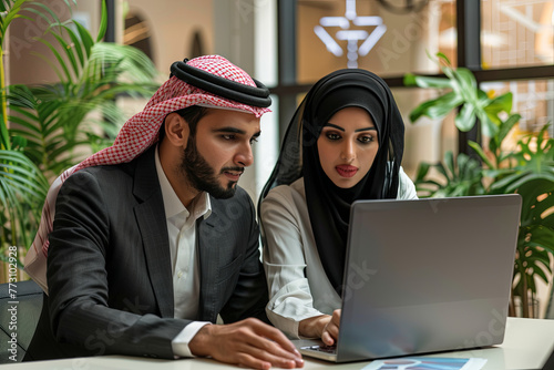 Business Meeting in office , arabian businessman & arabian Secretary wearing hijab working on laptop
 photo