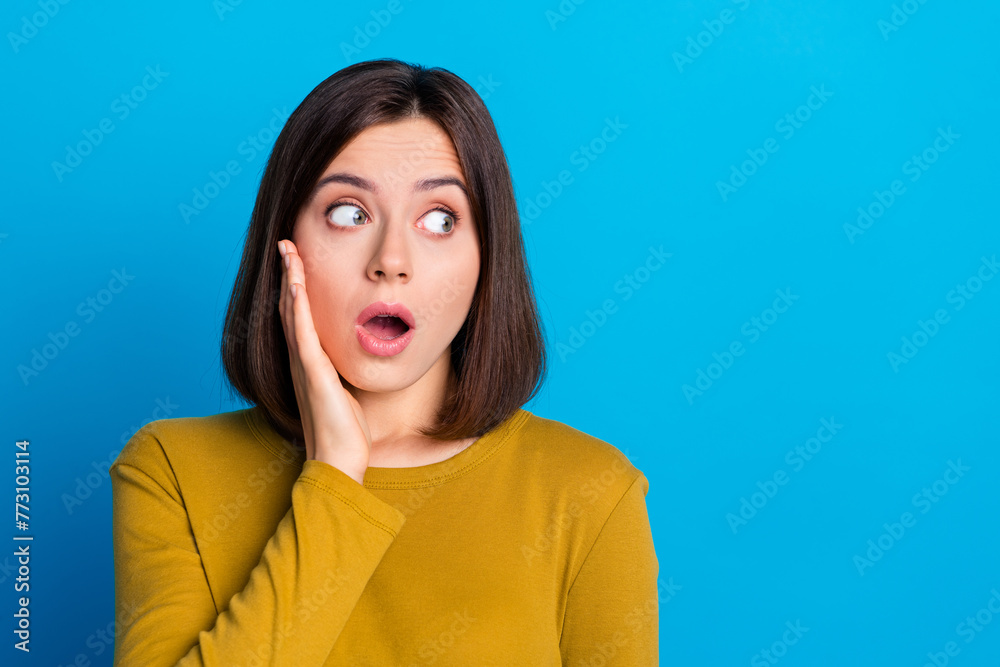 Photo of impressed funky woman wear shirt smiling arm cheek looking empty space isolated blue color background Photo of impressed funky woman wear shirt smiling arm cheek looking empty space isolated blue color background