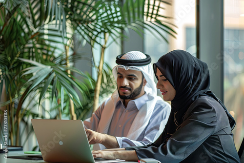 Business Meeting in office , arabian businessman & arabian Secretary wearing hijab working on laptop
 photo