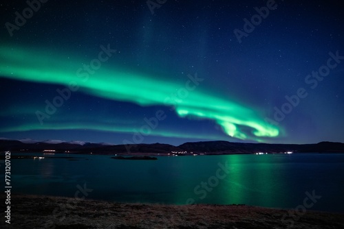 Stunning night sky illuminated by the Norther lights. Hvalfjordur, Iceland.