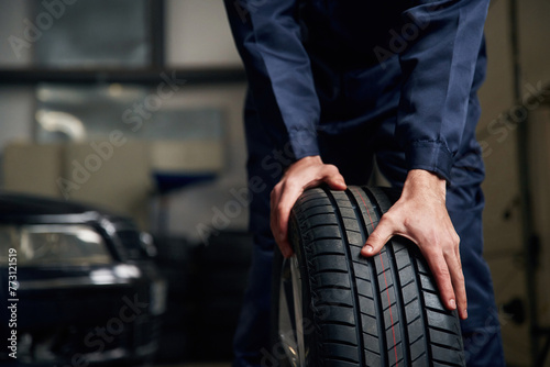 Close up view of man that is moving tire of the car