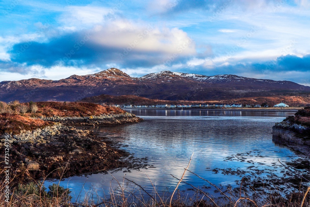 Aerial view of tranquil blue water and snowy mountains in Kyle of Lochalsh, Scotland, UK