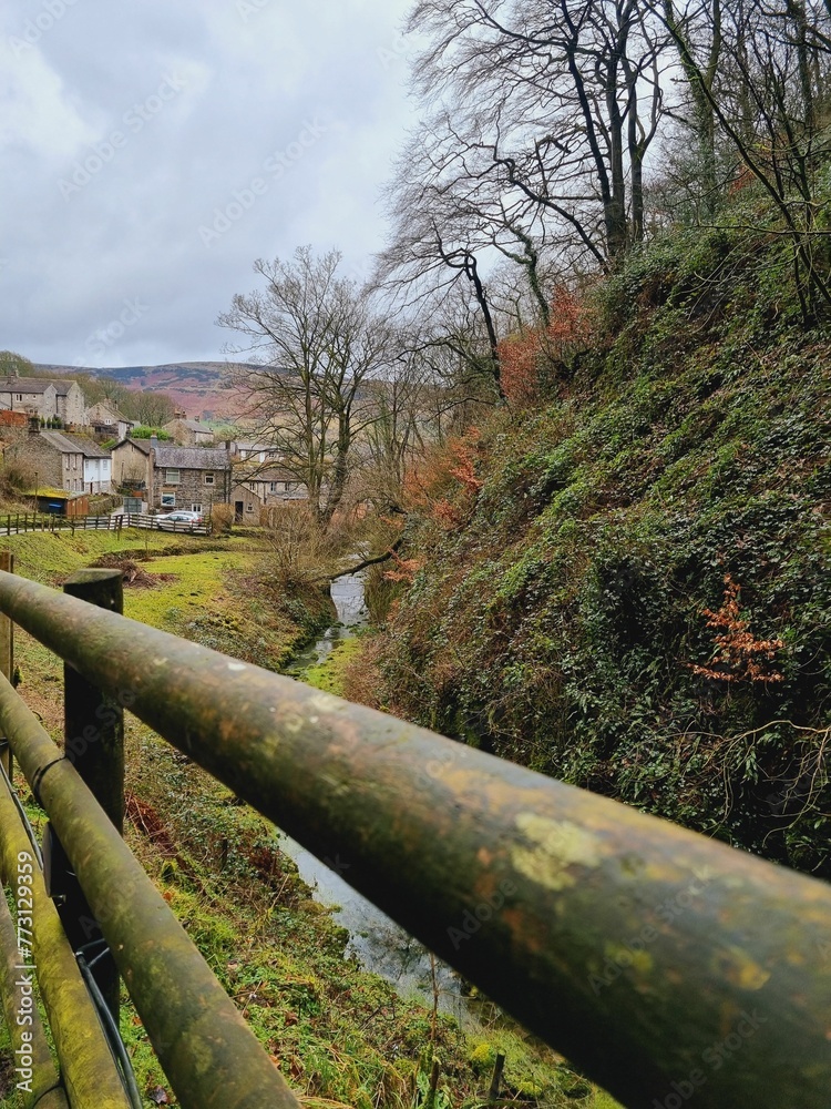 a fence in a rural area next to a stream and buildings a fence in a rural area next to a stream and buildings