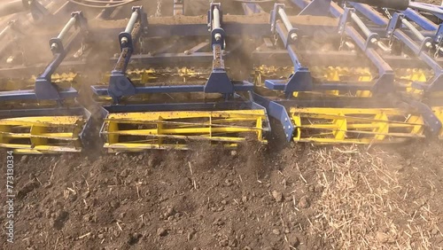 Large tractor with agricultural machinery cultivates the arable land and prepares the soil for sowing agricultural crops, slow motion