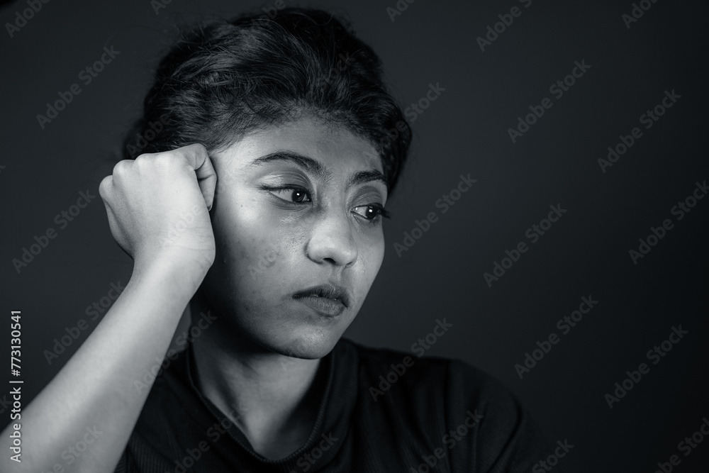 A woman with dark hair and a black shirt is looking down A woman with dark hair and a black shirt is looking down