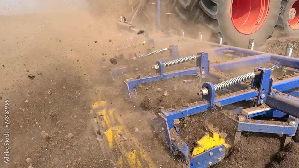 Large tractor with agricultural machinery cultivates the arable land and prepares the soil for sowing agricultural crops, slow motion