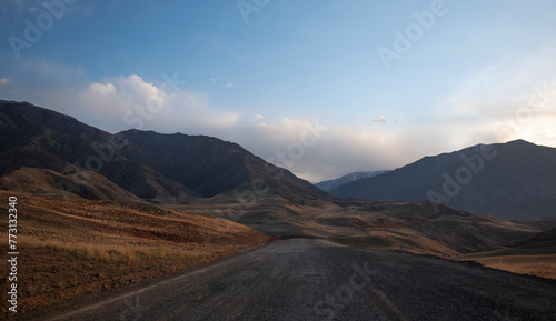 Fototapeta Naklejka Na Ścianę i Meble -  Kunlun Mountains in China. Mountain landscape background. Natural patterns on earth. Country road passing through the mountains during sunset.