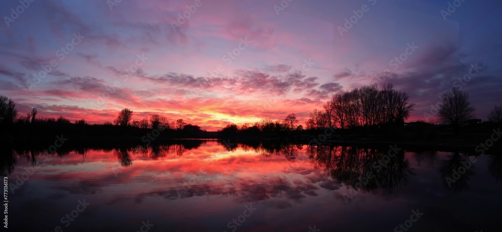 Sunset over lake surrounded by trees