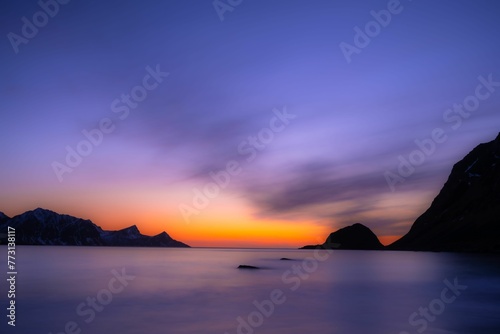 Stunning natural landscape of a sunset over the majestic mountains and the tranquil ocean