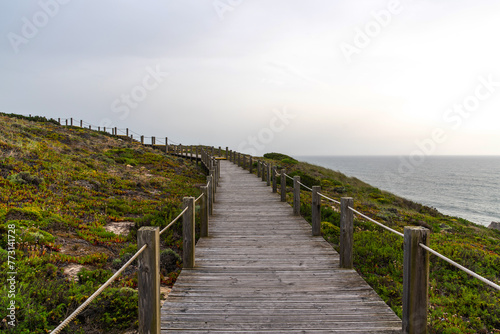 View of nature landscape ocean near Nazare. Wooden walkway to the beach, Portugal. Majestic coastline looking the Atlantic Ocean. © eskstock