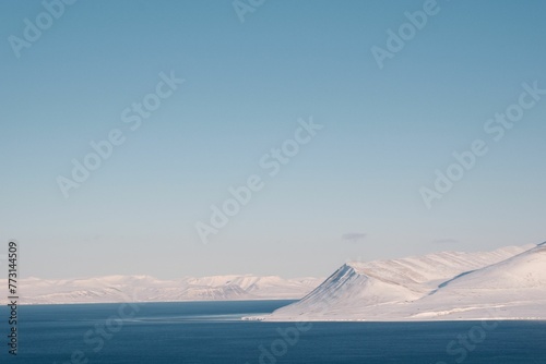 Scenic landscape of snow-covered mountains near a body of water in Svalbard