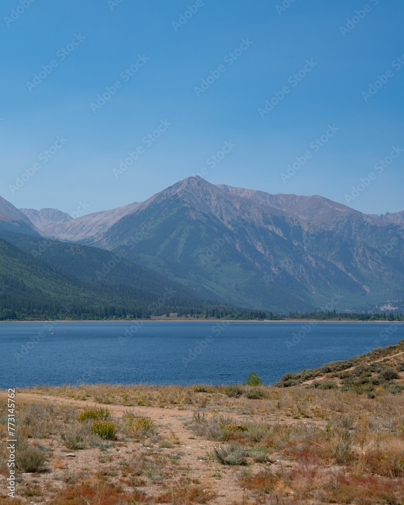 Scenic landscape of a tranquil blue lake with majestic mountains in the background