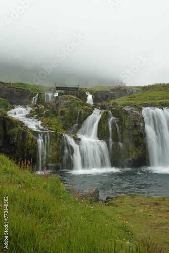 Vertical shot of flowing waterfalls on a cliff in Iceland © Wirestock