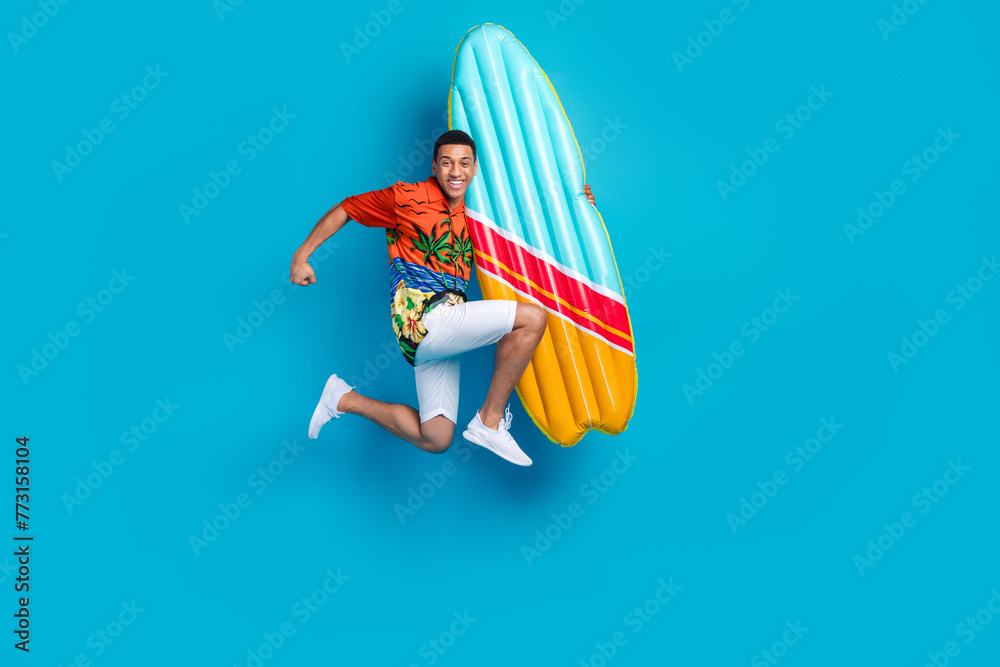 Full body photo of nice young man hold surfboard jump summer holiday isolated on blue color background - obrazy, fototapety, plakaty 
