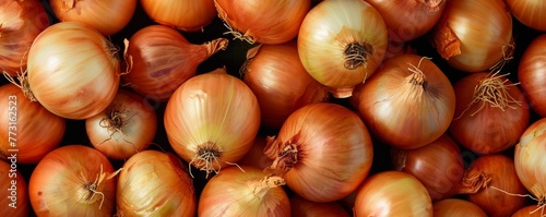   A pile of onions stacked upon one another, atop another larger pile