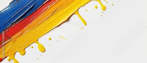   A tight shot of multicolored paint splatters covering a pristine white background, featuring red, yellow, blue, and green stripes photo
