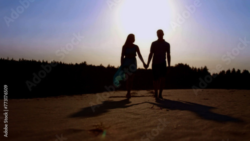 Silhouette of a couple in love on the beach at sunset