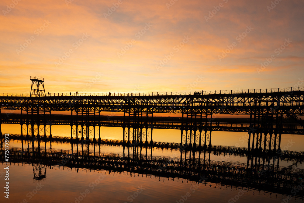 Captivating sunset scenery unfolds at The Rio Tinto Pier (Muelle de Rio Tinto) in Huelva, Andalusia, Spain