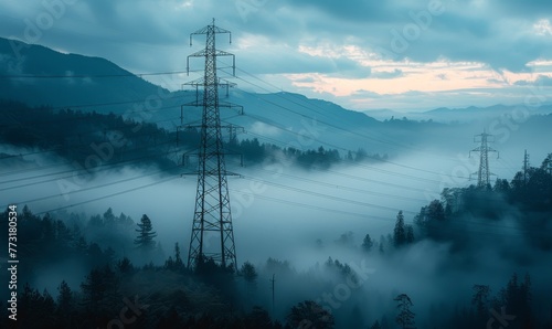 Aerial view of electricity transmission towers in a mountainous region, dense fog blanketing the ground with only the tops of the towers and mountains visible