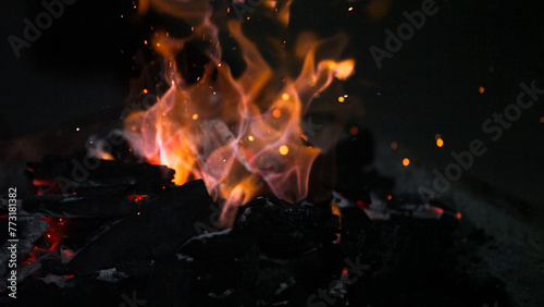 Burning coals in a barbecue, close-up, dark background