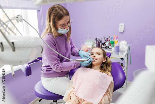 The process of using a dental brush during the stages of a professional teeth cleaning procedure in a clinic, pediatric dentistry