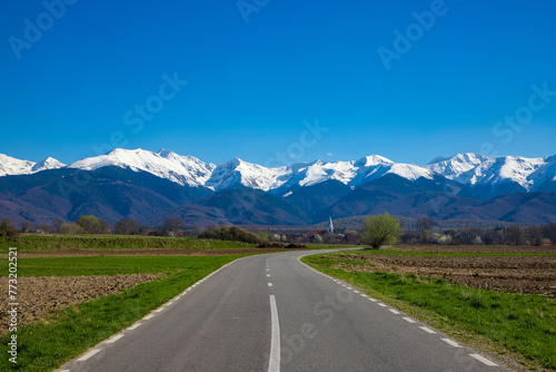 Landscape with Fagaras mountains with snowy peaks. Carpathian mountains seen in spring in Romania